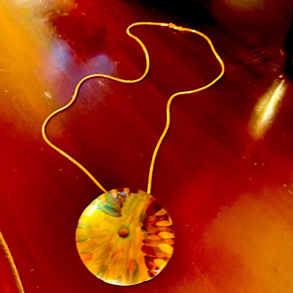 Statement necklace rose gold tone with round metallic medallion attached.